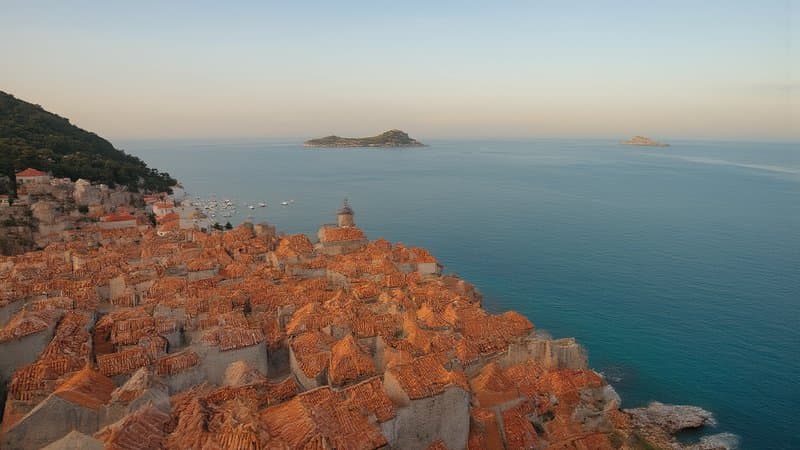 Muralhas e telhados de Dubrovnik vistos do alto com o Adriático turquesa