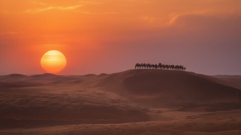 Dunas do Saara ao pôr do sol com caravana ao longe